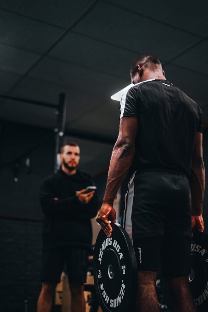 Focused strength training with a personal trainer in a gym setting.