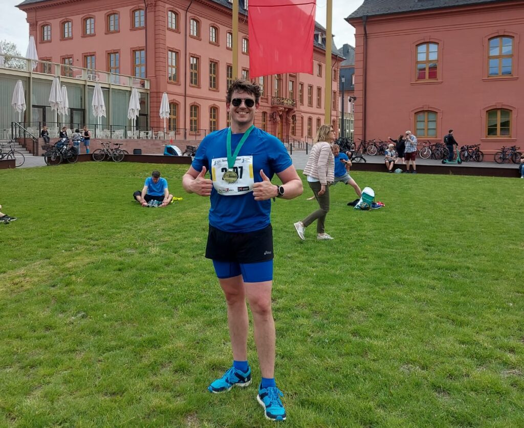 nach dem Halbmarathon-Finish in Mainz mit Medaille und Startnummer